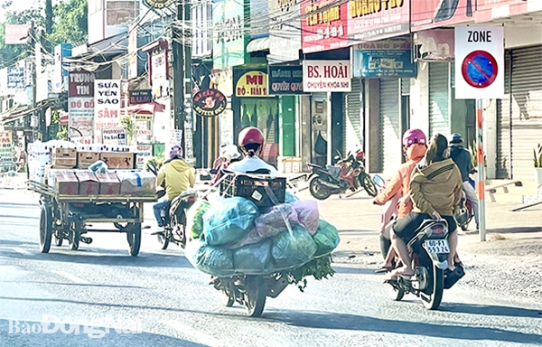 Nhiều xe máy, xe ba gác tự chế chở hàng cồng kềnh, ràng buộc lỏng lẻo trên quốc lộ 1 (đoạn qua P.Tân Hòa, TP.Biên Hòa)