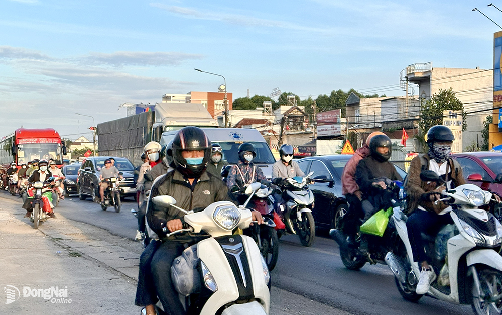 Nhiều người đi xe máy phải chạy dạt vào lề đường vì lượng xe di chuyển quá đông. Hình chụp trên quốc lộ 1 (hướng H.Trảng Bom - TP.Biên Hòa) đoạn qua H.Trảng Bom trong chiều 29-1. Ảnh: Công Nghĩa