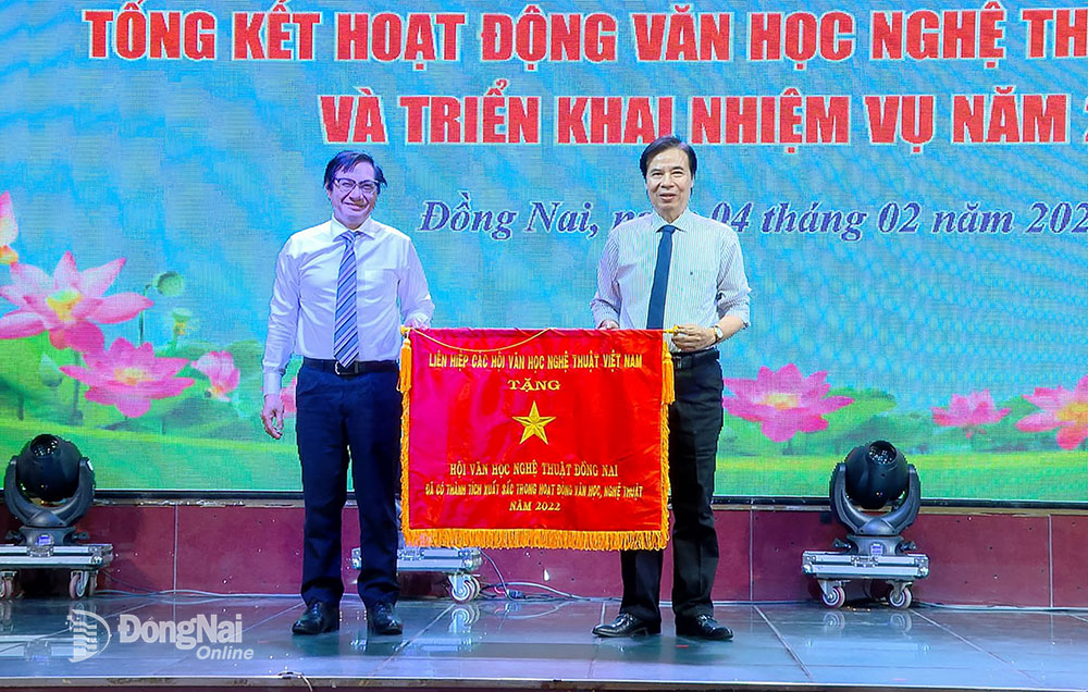 Phó chủ tịch UBND tỉnh Nguyễn Sơn Hùng trao cờ thi đua của Liên hiệp các Hội Văn học nghệ thuật Việt Nam cho Hội Văn học nghệ thuật Đồng Nai. Ảnh: M.Ny