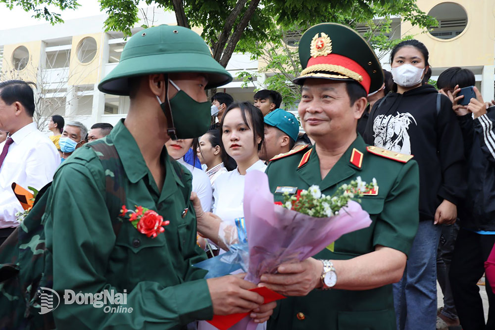 Trung tướng Trần Hoài Trung, Bí thư Đảng ủy, Chính ủy Quân khu 7 tặng hoa động viên tân binh lên đường nhập ngũ. Ảnh: Nguyệt Hà