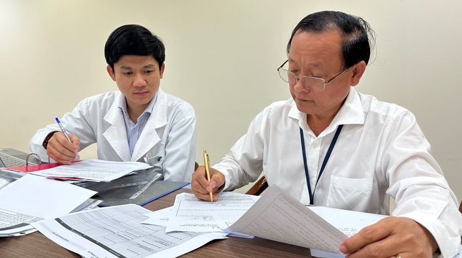 Thành viên đoàn kiểm tra của Sở Y tế (phải) kiểm tra một số tiêu chí của bệnh viện