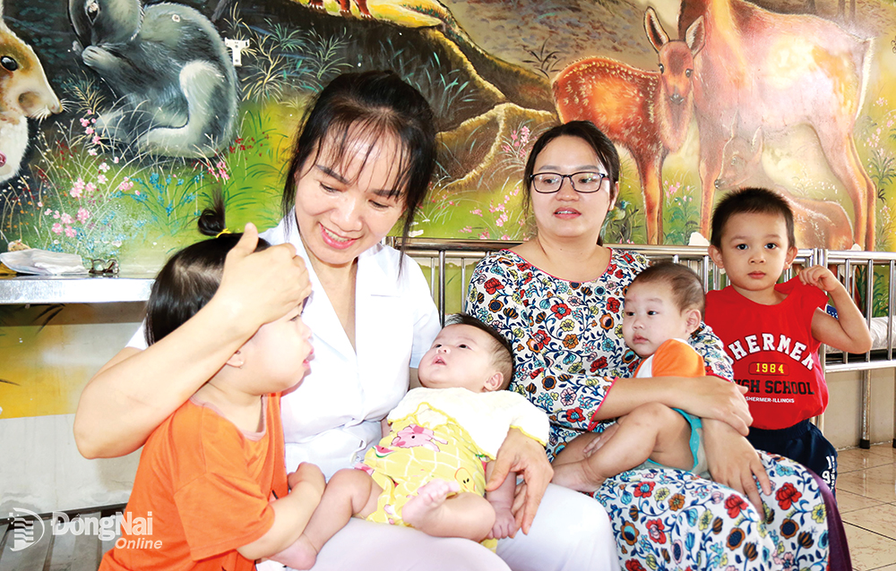 Trẻ em mồ côi tại Trung tâm Công tác xã hội tỉnh được các cô chăm sóc, dỗ dành