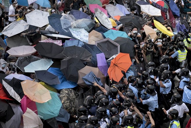 Người biểu tình tại Hong Kong sử dụng ô để chống vòi rồng và hơi cy của cảnh sát (Nguồn: Reuters)