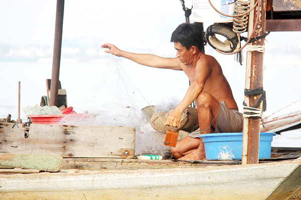 7. Trong những năm gần đây, người dân xóm Câu Bửu Hòa chuyển sang đánh bắt bằng lưới nhiều hơn. Trong ảnh: Một ngư dân xóm Câu Bửu Hòa chuẩn bị lưới để bắt cá