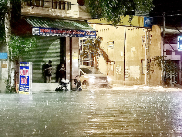 Đường Đồng Khởi đoạn gần ngã ba Trảng Dài (TP.Biên Hòa) ngập nước, nhiều ô tô, xe máy chết máy trên đường sau cơn mưa tối 26-4. Ảnh: T.Tâm