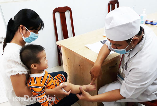 Bác sĩ Bệnh viện Nhi đồng Đồng Nai thăm khám cho bệnh nhi mắc bệnh tay chân miệng. Ảnh: Hạnh Dung