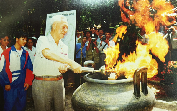 Đồng chí Mai Chí Thọ, nguyên Bí thư Khu ủy miền Đông châm lửa truyền thống tại lễ kỷ niệm 51 năm thành lập Chiến khu Đ. Ảnh: Phan Dẫu