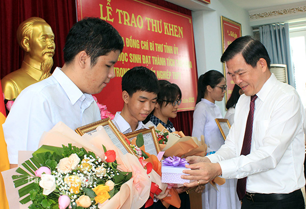 Bí thư Tỉnh ủy Nguyễn Hồng Lĩnh trao thư khen và quà cho các em học sinh đạt thành tích thủ khoa trong kỳ thi tốt nghiệp THPT năm 2022. Ảnh: Nga Sơn