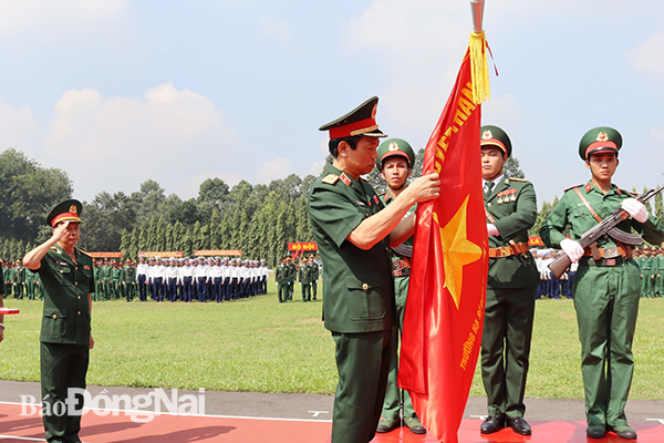 Thừa ủy quyền của Chủ tịch nước, thiếu tướng Nguyễn Đức Dinh gắn Huân chương và trao Huân chương Bảo vệ Tổ quốc hạng Nhì cho nhà trường