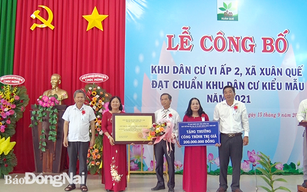 Ông Huỳnh Tấn Thìn, Chủ tịch UBND huyện và Ông Lê Văn Tưởng, Phó chủ tịch UBND huyện trao bằng và bảng tượng trưng cho khu dân cư Y1, xã Xuân Quế 