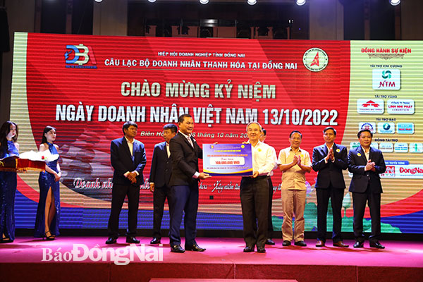 Ủy viên Ban TVTU, Chủ tịch UBMTTQ Việt Nam tỉnh Cao Văn Quang nhận bảng tượng trưng kinh phí để xây dựng nhà đại đoàn kết cho người nghèo do đại diện CLB Doanh nhân Thanh Hóa tại Đồng Nai trao tặng. Ảnh: Huy Anh