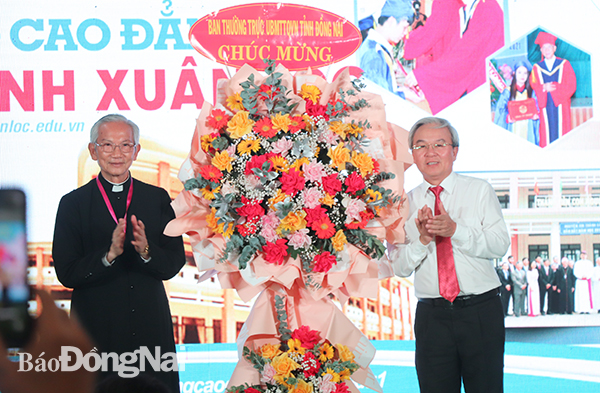 Đồng chí Cao Văn Quang, Chủ tịch Ủy ban MTTQ Việt Nam tỉnh tặng hoa chúc mừng Trường cao đẳng Hòa Bình Xuân Lộc.
