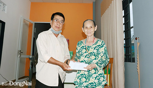 Ông Hoàng Mậu Tú, Trưởng ban Công tác Mặt trận ấp Lộ 25 (xã Hưng Lộc, H.Thống Nhất) tặng quà vận động được cho một hoàn cảnh khó khăn