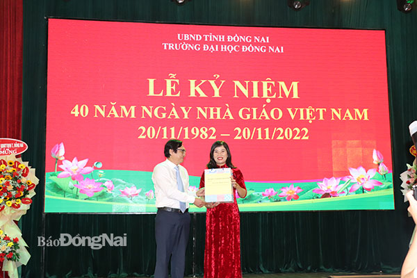 Phó chủ tịch UBND tỉnh Nguyễn Sơn Hùng tặng quà cho PGS-TS Huỳnh Bùi Linh Chi, Trưởng phòng Đào tạo, Trường đại học Đồng Nai. Đây là nữ PGS đầu tiên của Trường đại học Đồng Nai