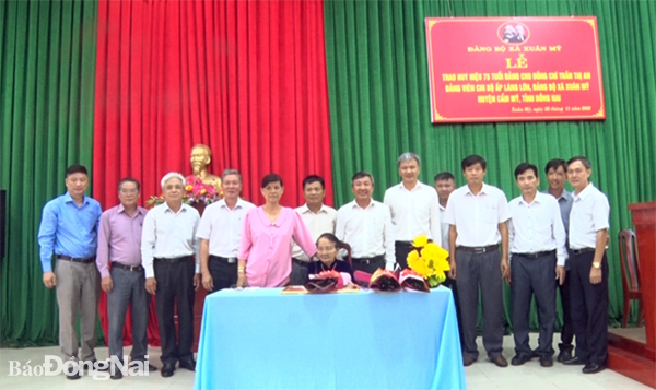 Phó bí thư thường trực Tỉnh ủy Hồ Thanh Sơn (đứng, hàng đầu, thứ 5 từ phải qua) cùng  lãnh đạo huyện, xã chụp hình lưu niệm với đồng chí Trần Thị An