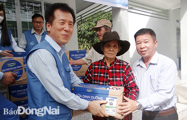 Tổng giám đốc Công ty TNHH POSCO VST Lee Jong Yeob (bên trái) và lãnh đạo MTTQ xã Phước Thiền tặng quà cho hộ nghèo